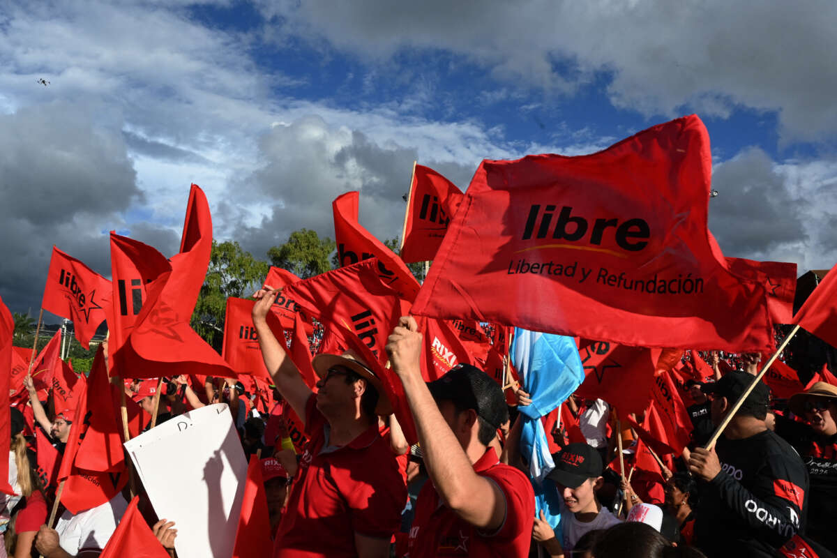 Supporters of the presidential candidate for the ruling Libertad y Refundacion (LIBRE) party, Rixi Moncada, wave flags during a protest rally demanding guarantees for free, fair, and transparent elections in Honduras at a baseball field in Tegucigalpa, Honduras, on November 9, 2025.