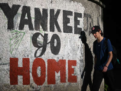 A man walks past a mural that reads, "Yankee go home" in Caracas, Venezuela, on November 13, 2025.