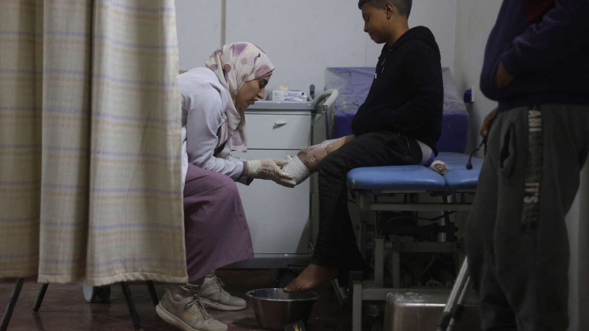 A medical personnel assists a young displaced Palestinian amputee at the Sheikh Hamad Hospital for Rehabilitation and Prosthetics in Gaza City, on November 16, 2025.