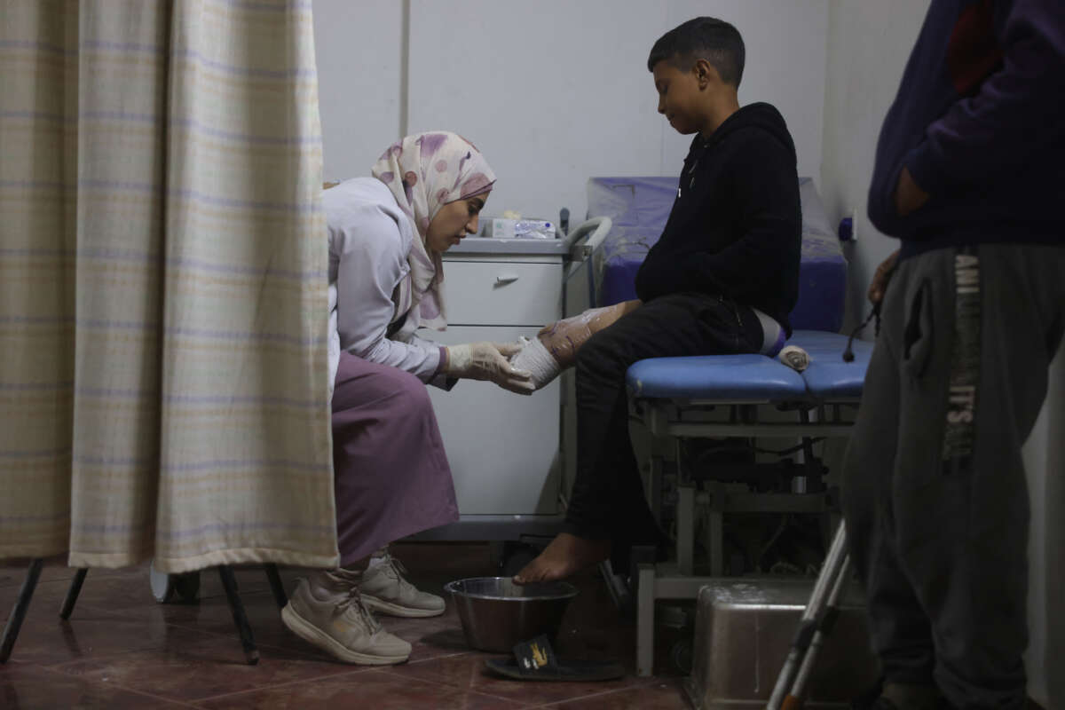 A medical personnel assists a young displaced Palestinian amputee at the Sheikh Hamad Hospital for Rehabilitation and Prosthetics in Gaza City, on November 16, 2025.