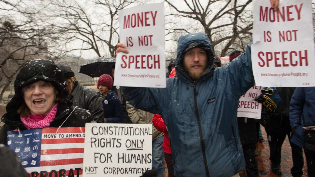 Demonstrators march through Lafayette Park, outside the White House, to the U.S. Chamber of Commerce during a rally against the Supreme Court's decision in Citizens United, which allows private citizens and corporations to make unlimited donations for political campaigns, in Washington, D.C., on January 21, 2015.
