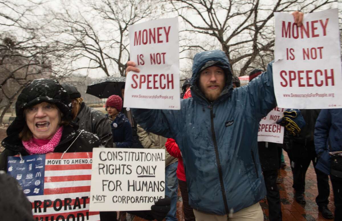 Demonstrators march through Lafayette Park, outside the White House, to the U.S. Chamber of Commerce during a rally against the Supreme Court's decision in Citizens United, which allows private citizens and corporations to make unlimited donations for political campaigns, in Washington, D.C., on January 21, 2015.