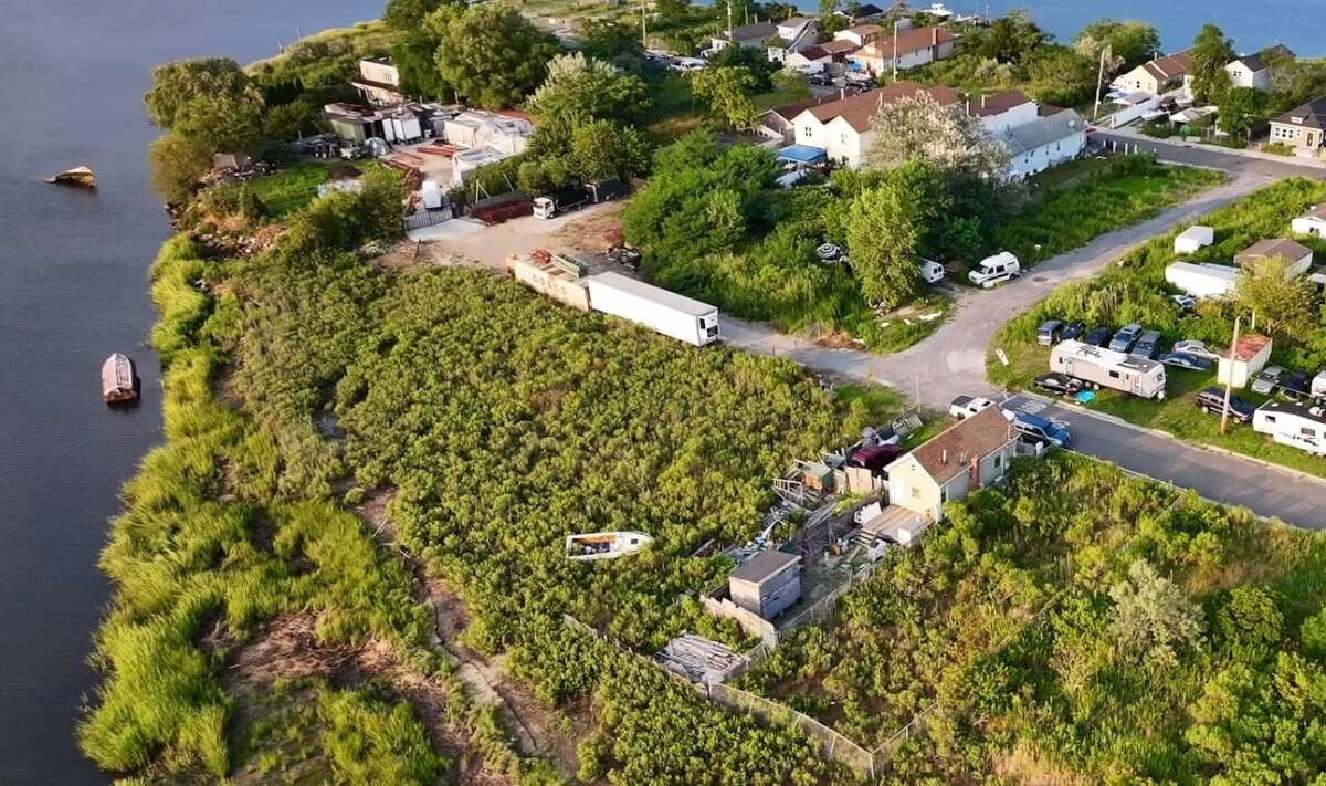 Remnants of the destruction of 2012’s Superstorm Sandy, including debris and a scuttled boat, still lay beside Baba Ndanani’s home on Edgemere’s bayside peninsula. Ten years after city officials pledged to raise Edgemere’s bayside shoreline, the project has yet to break ground.