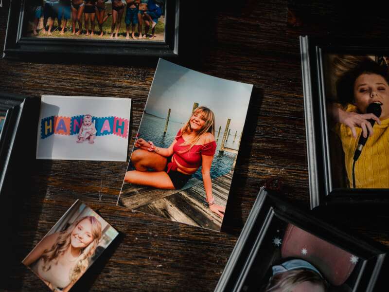 Old photos of Hannah Goetz sit on the dining room table in Portsmouth, Virginia, on April 4, 2025. Hannah Goetz was in fourth grade when doctors figured out that her regular bouts of bronchitis and her struggle to gain weight were caused by cystic fibrosis.