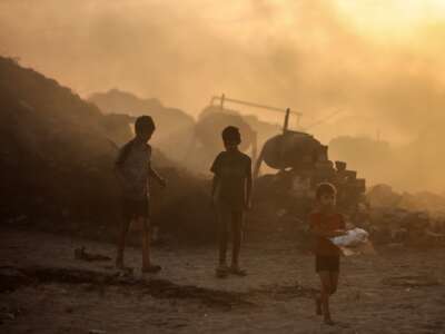 Displaced Palestinian children search for plastic to use for cooking near Gaza's port in Gaza, Palestine, on November 13, 2025.