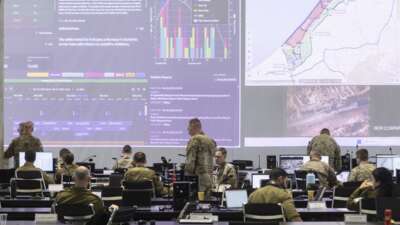 U.S. Army personnel, IDF personnel and others international officials monitor screens displaying maps and imagery of the Gaza Strip during a media tour inside the Civil-Military Coordination Center (CMCC) on November 20, 2025 in Kiryat Gat, Israel.