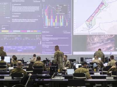 U.S. Army personnel, IDF personnel and others international officials monitor screens displaying maps and imagery of the Gaza Strip during a media tour inside the Civil-Military Coordination Center (CMCC) on November 20, 2025 in Kiryat Gat, Israel.