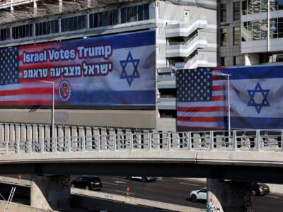 Large billboards bearing the flags of the U.S. and Israel with a message in support of U.S. presidential candidate Donald Trump, hang against buildings in Tel Aviv on October 30, 2024.