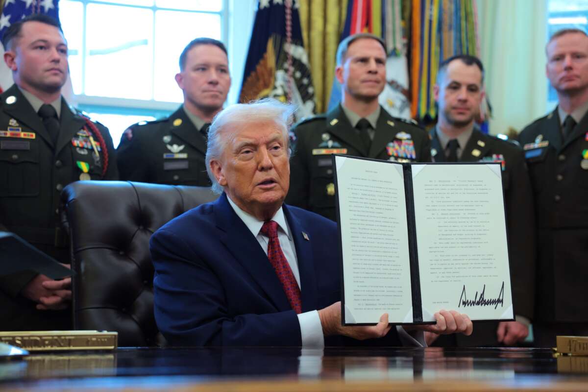 President Donald Trump poses with a recently signed executive order classifying fentanyl as a "weapon of mass destruction," during a ceremony for the presentation of the Mexican Border Defense Medal in the Oval Office of the White House on December 15, 2025 in Washington, D.C.