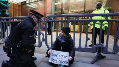 Activist Greta Thunberg joins the protest outside the offices of Aspen Insurance and holds a sign saying 'I support Palestine Action Prisoners I oppose Genocide' on December 23, 2025 in London, England.