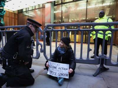 Activist Greta Thunberg joins the protest outside the offices of Aspen Insurance and holds a sign saying 'I support Palestine Action Prisoners I oppose Genocide' on December 23, 2025 in London, England.