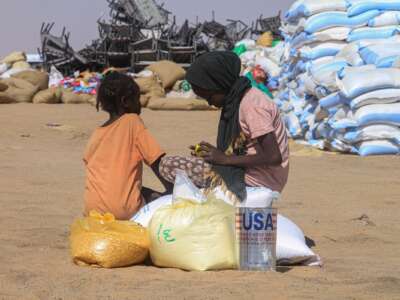Sudanese girls who fled El-Fasher receive humanitarian aid at the Al-Afad camp for displaced people in the town of Al-Dabba, northern Sudan, on November 25, 2025.