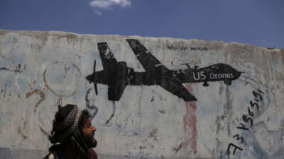A Yemeni man looks at graffiti protesting against U.S. drone strikes on September 19, 2018, in Sana'a, Yemen.