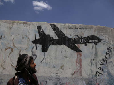 A Yemeni man looks at graffiti protesting against U.S. drone strikes on September 19, 2018, in Sana'a, Yemen.
