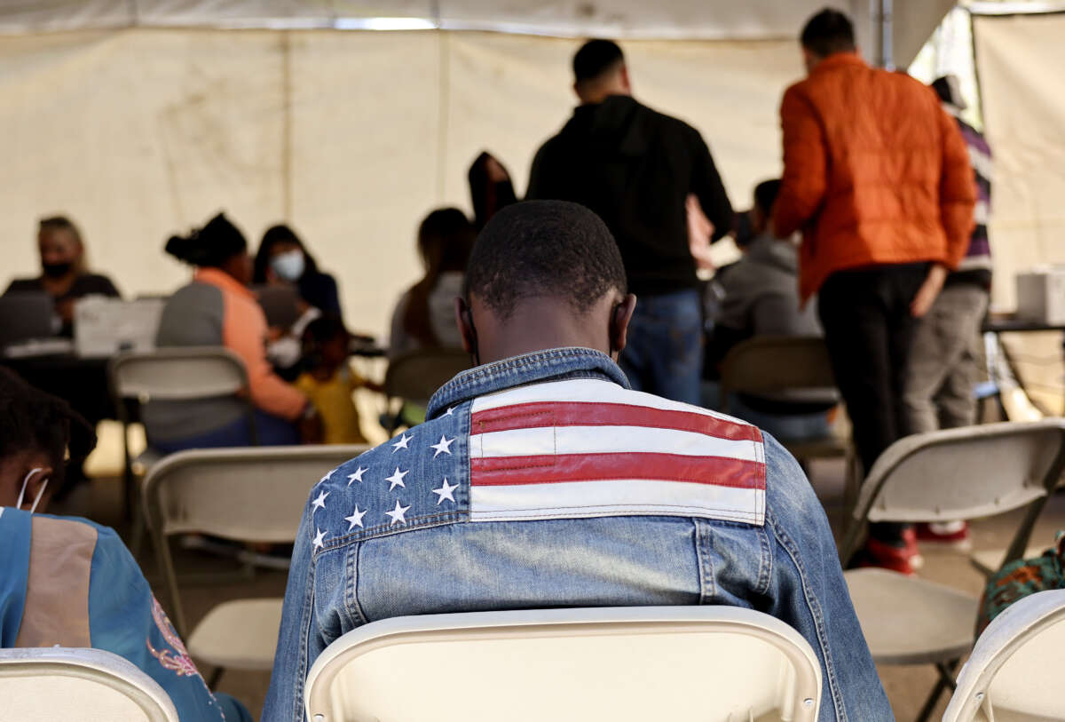 An immigrant from Ghana wears an American flag jacket at a migrant transition center for asylum seekers released from Border Patrol custody, after crossing into the United States, on May 12, 2023, in Somerton, Arizona.