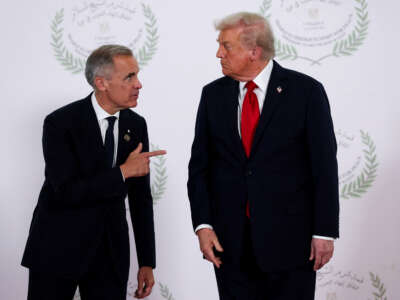 U.S. President Donald Trump and Canadian Prime Minister Mark Carney speak as they pose for a photo in Sharm El-Sheikh, Egypt, on October 13, 2025.