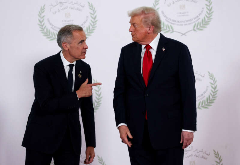 U.S. President Donald Trump and Canadian Prime Minister Mark Carney speak as they pose for a photo in Sharm El-Sheikh, Egypt, on October 13, 2025.