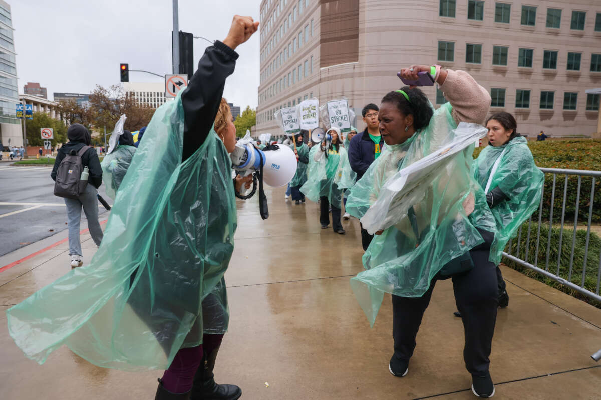 Two workers chant while participating in a strike in front of Ronald Reagan UCLA Medical Center on November 17, 2025 in Los Angeles, CA.