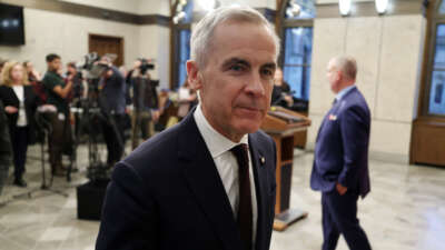 Canadian Prime Minister Mark Carney leaves after speaking with reporters about new measures to protect Canadian strategic industries in Parliament Hill, Ottawa, Ontario, Canada, on November 26, 2025.