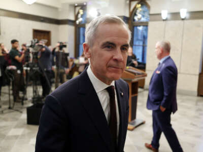 Canadian Prime Minister Mark Carney leaves after speaking with reporters about new measures to protect Canadian strategic industries in Parliament Hill, Ottawa, Ontario, Canada, on November 26, 2025.
