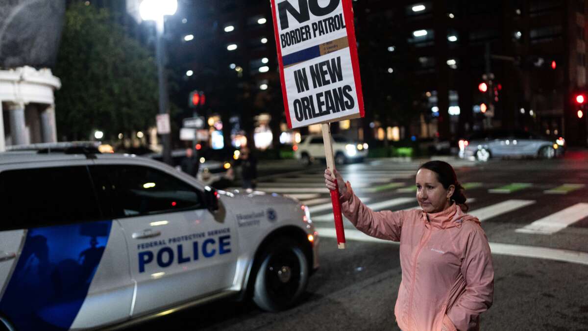 A woman holds a sign during a protest against the U.S. Border Patrol and Immigration and Customs Enforcement (ICE) outside of Hale Boggs Federal Building in New Orleans, Louisiana, on December 6, 2025.