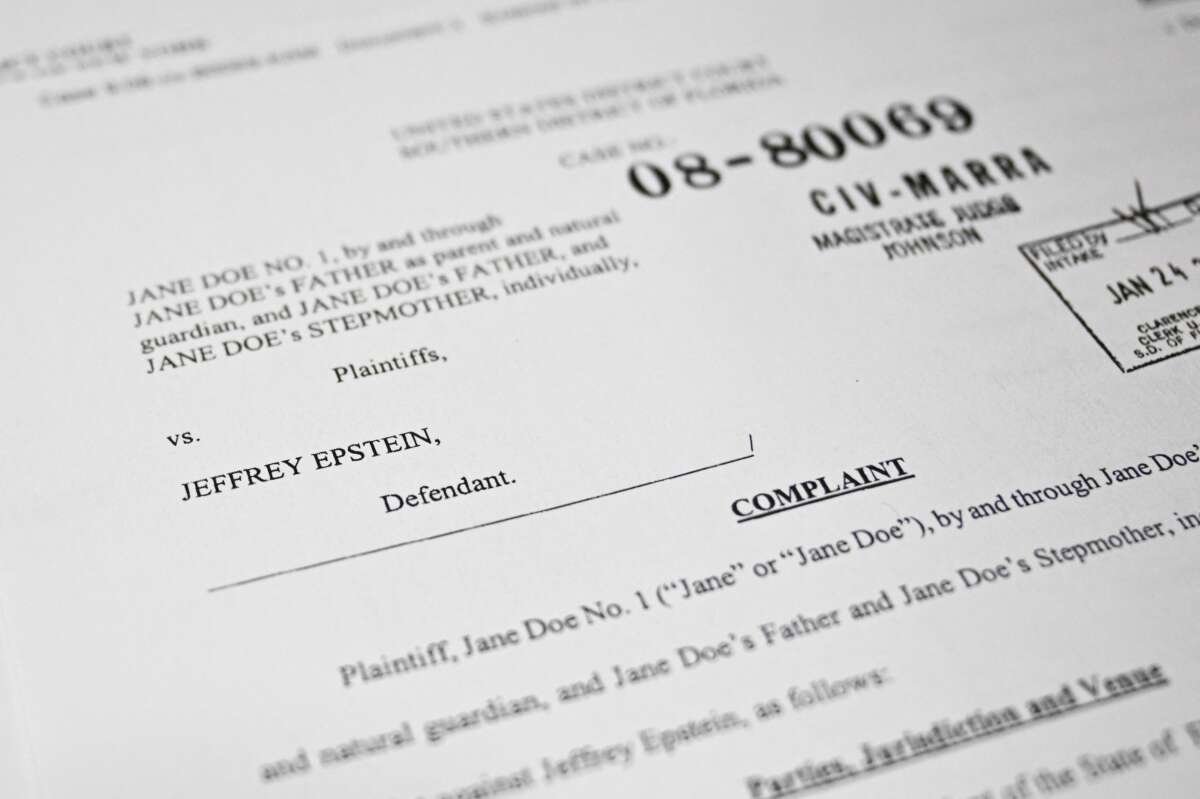 This photo illustration taken in Washington, D.C., on December 19, 2025, shows a court document after the US Justice Department began releasing the long-awaited records from the investigation into the politically explosive case of convicted sex offender Jeffrey Epstein.