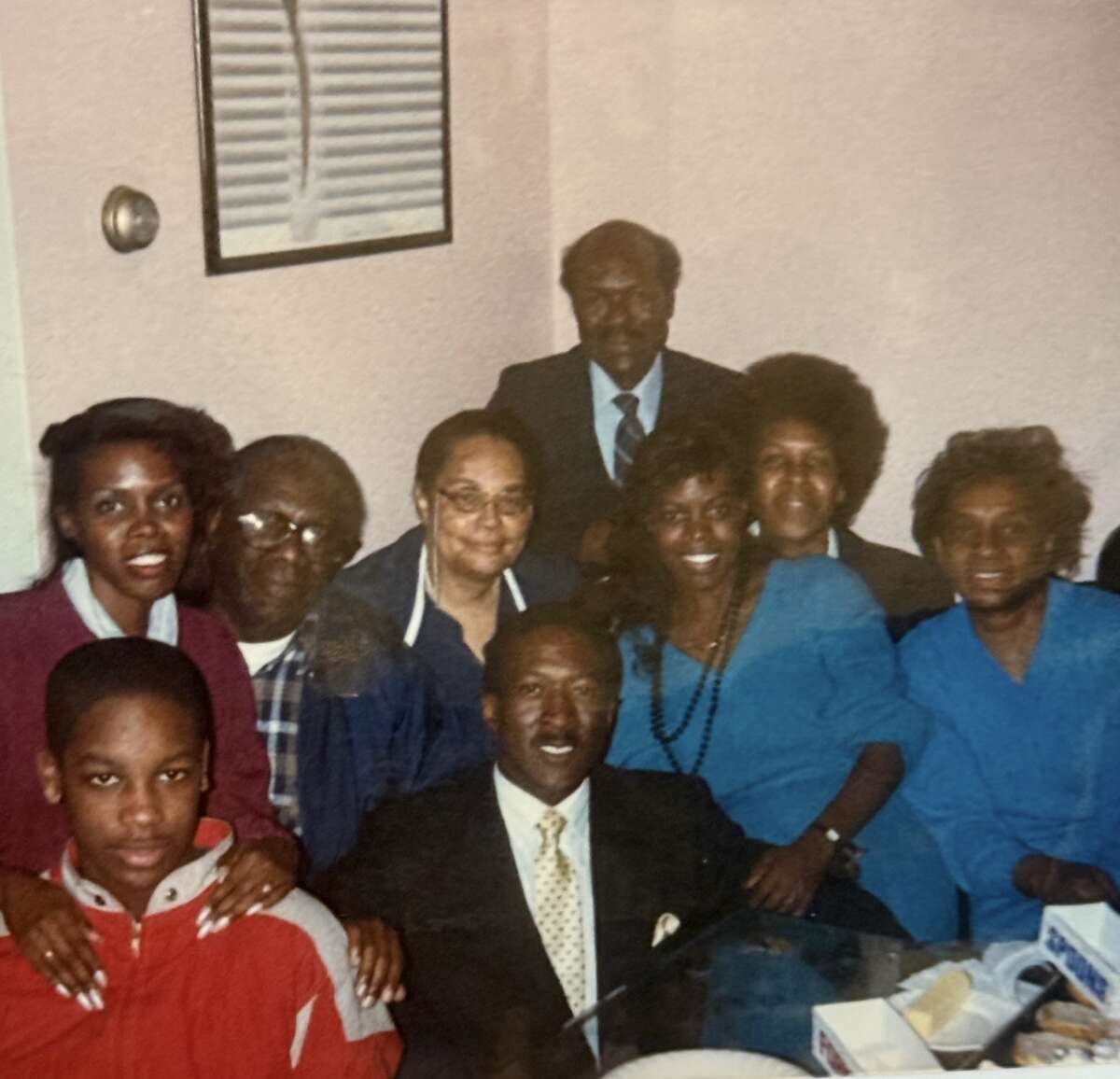 In this childhood family photo, Michael is in red, at front left. Gramma Aimee is second to the right, next to Aunt Stephanie in the blue and black beads.