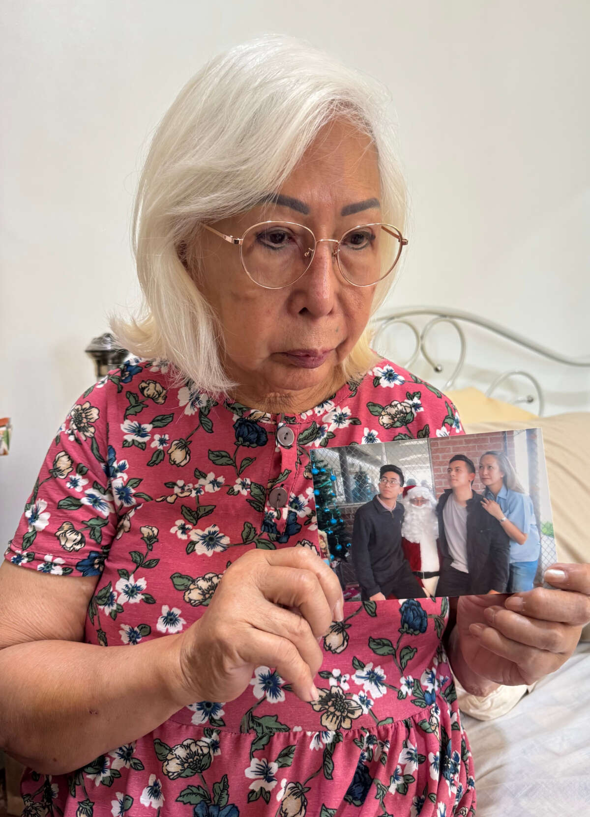 AnnaMaria Gana’s mother Evelyn holding a photo of Gana, her two sons and Santa Claus during a Christmas visit.