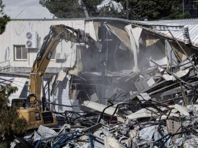 Heavy machinery pulling down a structure inside the UNRWA compound as the Israel Land Authority begins demolishing an UNRWA complex on January 20, 2026 in Jerusalem.