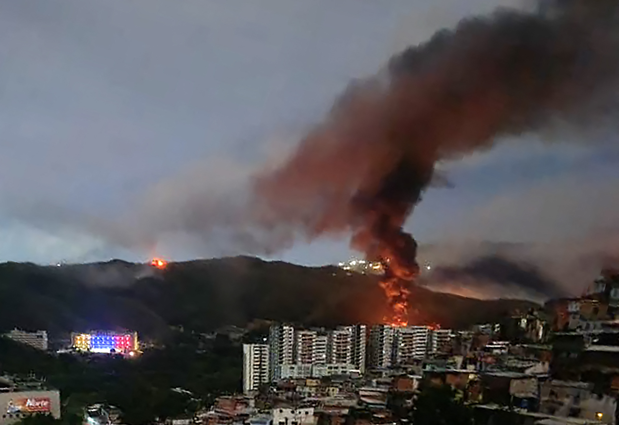 Fire at Fuerte Tiuna, Venezuela's largest military complex, is seen from a distance after a series of U.S. military strikes against Caracas on January 3, 2026.