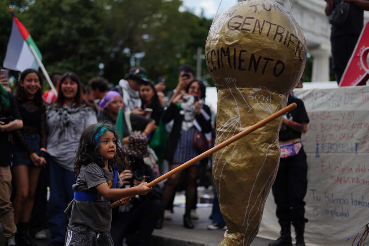 A child hits a piñata of a World Cup trophy during an anti-gentrification protest in Mexico City.