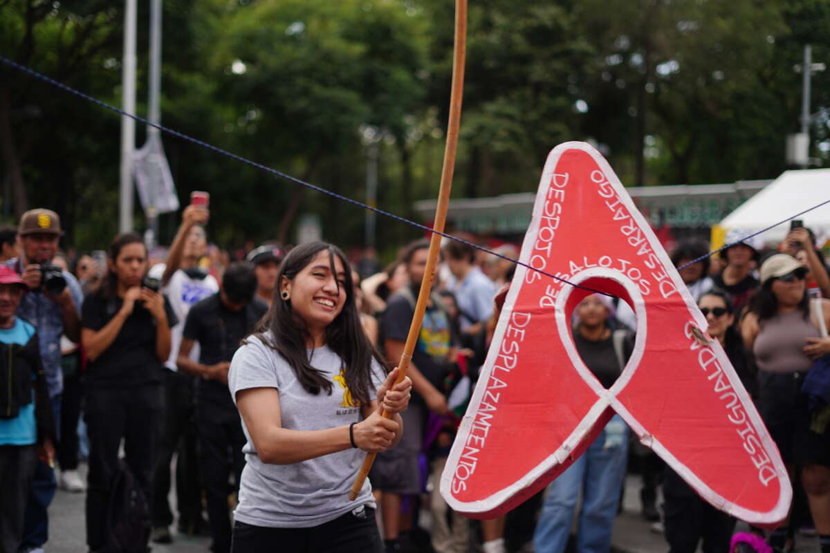 Protesters in Mexico City denouncing gentrification take turns to hit an AirBnb piñata that is covered in words like 'displacement,' and 'inequality.'