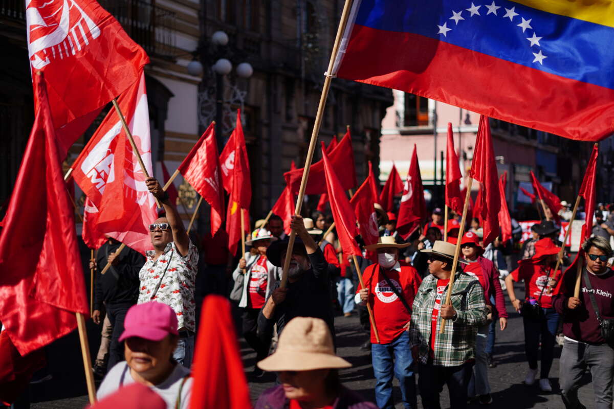 People wave a Venezuelan flag at the anti-imperialist march in Puebla, January 10.