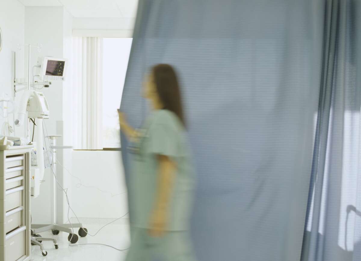 doctor closing curtain in hospital room