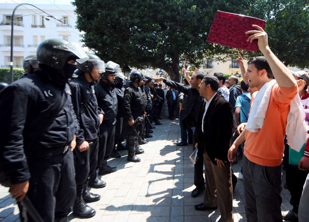 Tunisian riot police block the central Habib Bourguiba Avenue in Tunis on May 6, 2011, during a demonstration organized by youths denouncing the transitional government and calling for "a new revolution." Riot police used tear gas and truncheons to break up a protest in central Tunis on May 6, attacking reporters and photographers covering the event.
