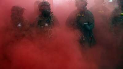 Federal agents, including members of the Department of Homeland Security and the Border Patrol, deploy a smoke grenade outside a downtown Immigration and Customs Enforcement facility in Portland, Oregon, on October 4, 2025.