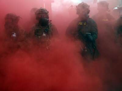 Federal agents, including members of the Department of Homeland Security and the Border Patrol, deploy a smoke grenade outside a downtown Immigration and Customs Enforcement facility in Portland, Oregon, on October 4, 2025.