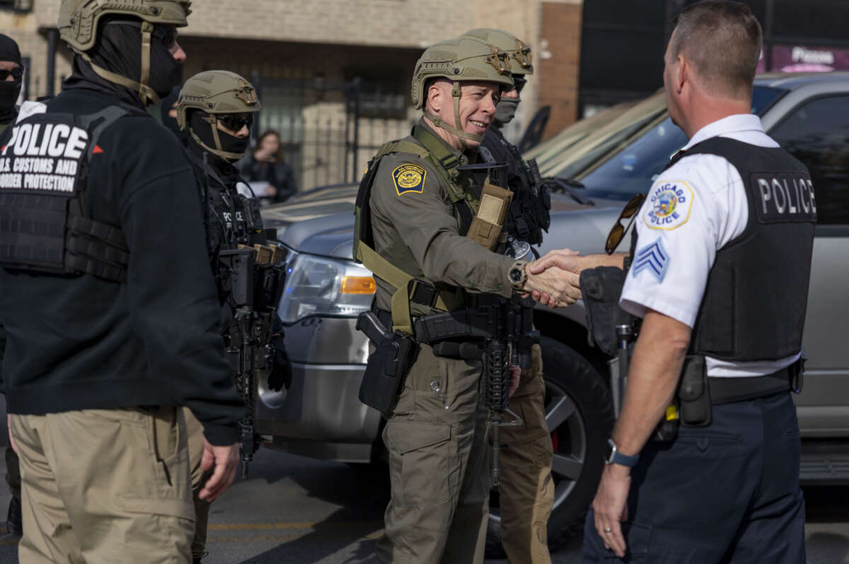 Border Patrol Cmdr Gregory Bovino shakes hands with Chicago police Sgt. Glenn Polanek while the Border Patrol's convoy of vehicles stopped on November 6, 2025, next to Marquette Park on Chicago's South Side.