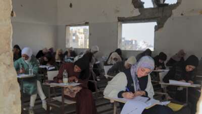 Students take their exams in a damaged classroom at the Al-Azhar institutes in Gaza City on November 18, 2025.