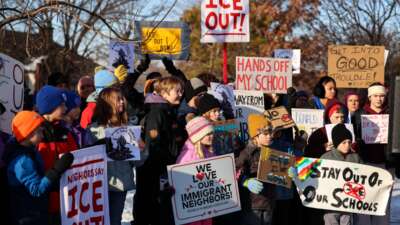 People pause for a minute of silence during a press conference organized by the group "Minneapolis Families for Public Schools," in Minneapolis, Minnesota, on January 9, 2026.