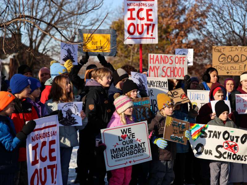 People pause for a minute of silence during a press conference organized by the group "Minneapolis Families for Public Schools," in Minneapolis, Minnesota, on January 9, 2026.