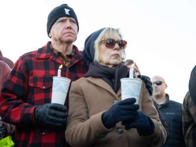 Gov. Tim Walz and First Lady Gwen Walz hold candles on the Capitol steps in St. Paul, Minnesota, as participants in an interfaith vigil remember the life of Renee Nicole Good.