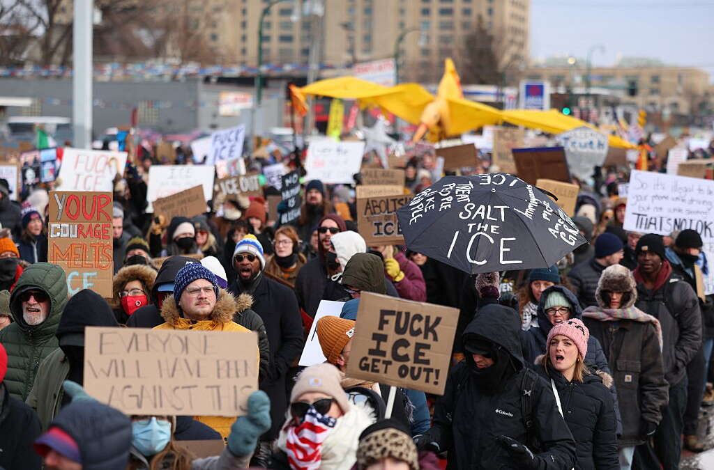 People holding up signs protest on the streets