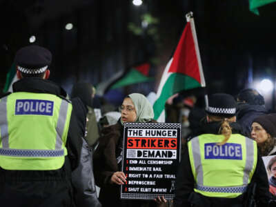 Shamina Alam, the sister of hunger striker Kamran Ahmed, holds a sign outlining the hunger striker's demands in London, UK, on January 11, 2026.