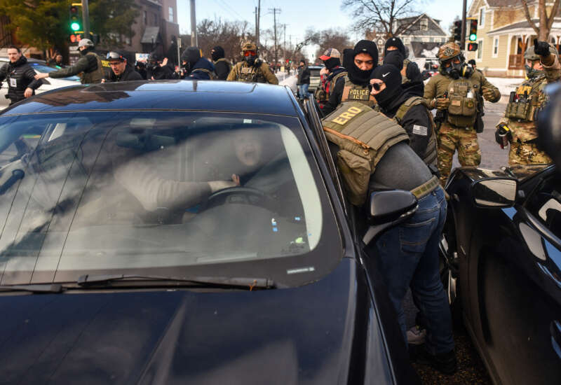ICE agents and other federal officers remove a woman from her vehicle in Minneapolis, Minnesota, on January 13, 2026.