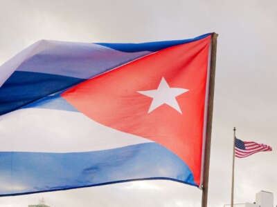 A Cuban soldier waves a national flag as he takes part in a protest in front of the U.S. Embassy against the U.S. incursion in Venezuela, where 32 Cuban soldiers lost their lives, in Havana, Cuba, on January 16, 2026.