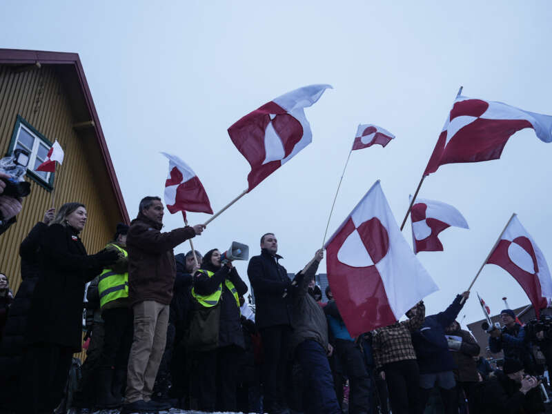 People wave Greenlandic flags as they take part in a demonstration that gathered almost a third of the city population to protest against the U.S. President's plans to take Greenland, on January 17, 2026, in Nuuk, Greenland.