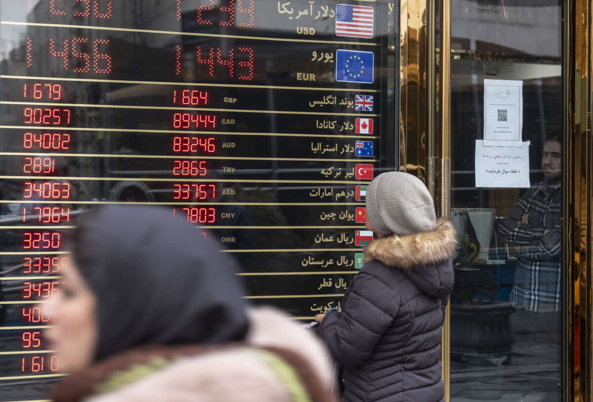 An Iranian woman looks at an electronic board displayed outside a currency exchange shop in downtown Tehran, Iran, on January 20, 2026, following recent unrest in Iran.