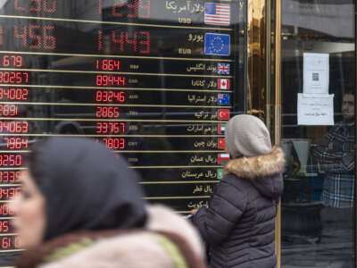 An Iranian woman looks at an electronic board displayed outside a currency exchange shop in downtown Tehran, Iran, on January 20, 2026, following recent unrest in Iran.