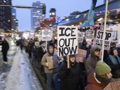 Demonstrators march during the nationwide "Stop ICE Terror" rally through downtown Minneapolis, Minnesota, on January 20, 2026, in protest against Donald Trump's policies.